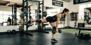 Female athlete performing a single-leg Romanian Deadlift (RDL) in a gym